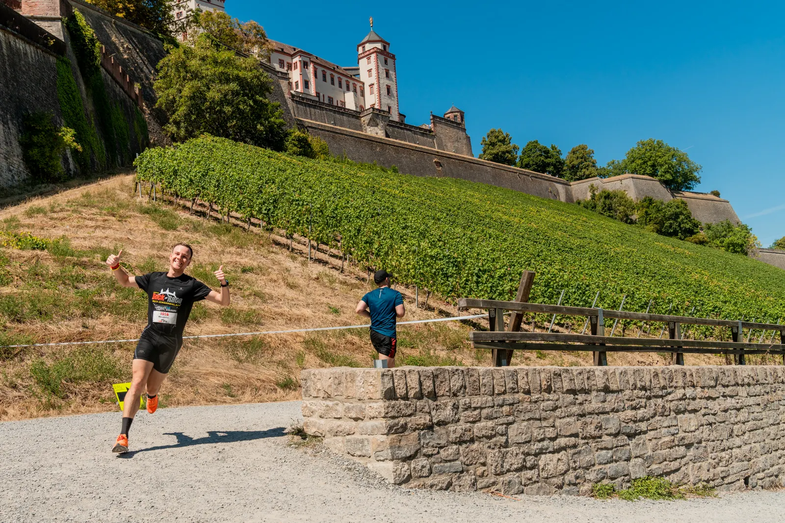 Läufer auf dem Weg unterhalb der Festung Marienberg zwischen Weinbergen
